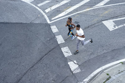 Couple running on road together at city