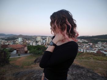 Woman standing in city against sky