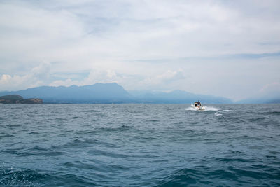 Scenic view of sea against sky with a speedboat at lake garda italy