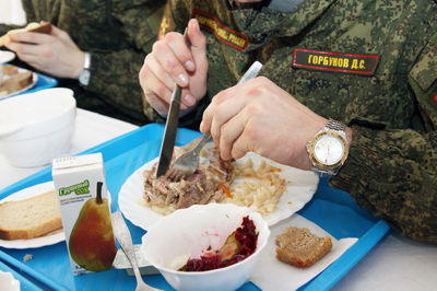 Midsection of person having food on table