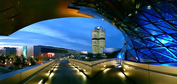 Illuminated modern buildings against sky in city