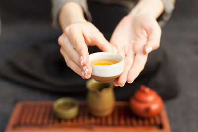 Midsection of person holding drink on table