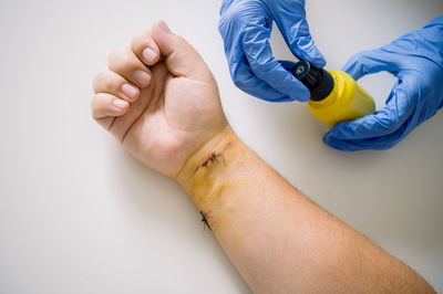 Cropped hand of doctor giving medicine against white background