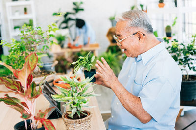 Midsection of man holding potted plant