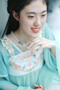 Close-up of young woman sitting at home