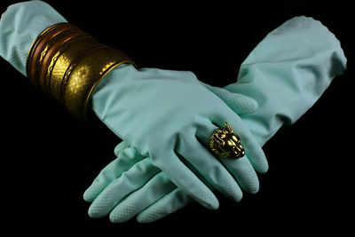 Close-up of hand holding umbrella against black background