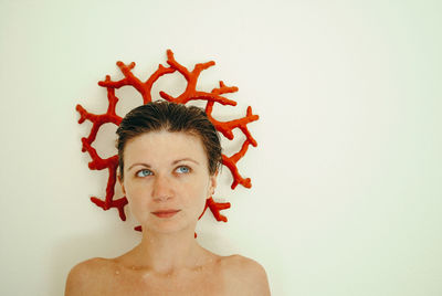 Close-up portrait of young woman against white background