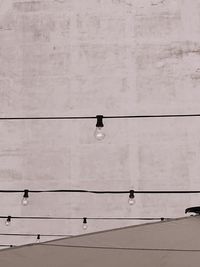 Low angle view of lighting equipment hanging on cable