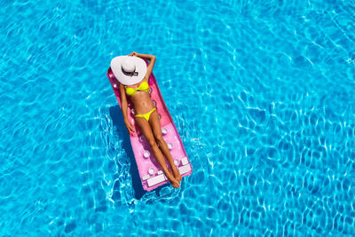 Woman floating in swimming pool