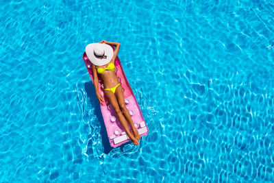 Woman floating in swimming pool