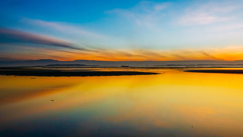 Scenic view of beach against sky during sunset