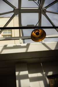 Low angle view of electric lamp hanging from ceiling