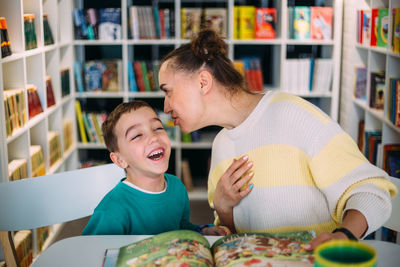 Mom and her little child, the preschooler son, read together children's books