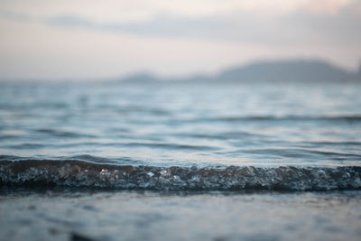 Surface level of sea against sky during sunset