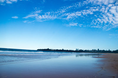 Scenic view of beach against blue sky