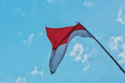 Low angle view of flag against blue sky