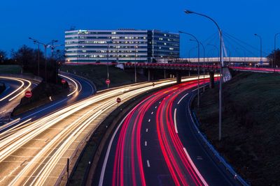 Light trails on road against sky at night