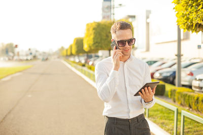 Young man using mobile phone in city