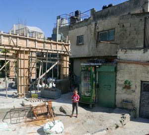 Rear view of woman standing by building