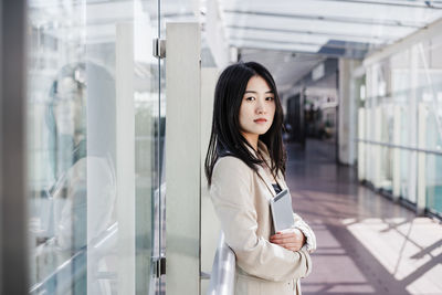 Portrait of young woman standing in city