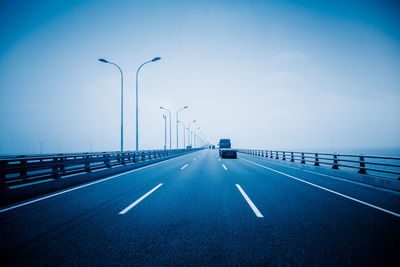 Street lights on highway against sky