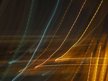 Low angle view of light trails against sky at night