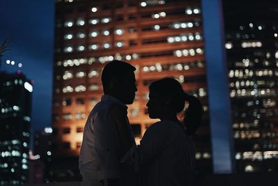 Couple kissing in city at night