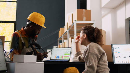 Side view of young woman working in office