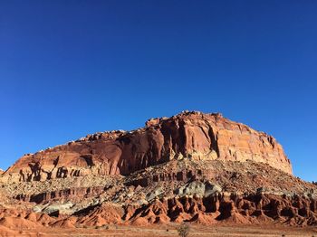 Rock formations on mountain against clear blue sky