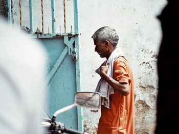 Side view of man working on wall