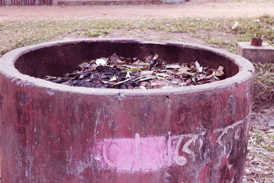 Close-up of rusty metal container on field