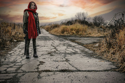 Rear view of woman standing on footpath against sky
