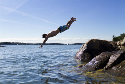 Young man jumping into water