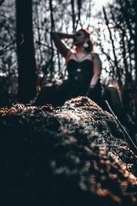 Low angle view of woman walking on tree trunk