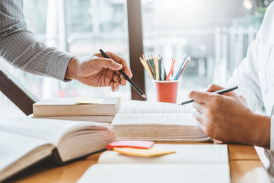 Cropped image of man reading book on table