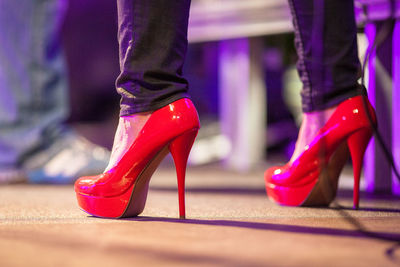 Low section of woman wearing red high heels