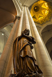 Low angle view of statue by column