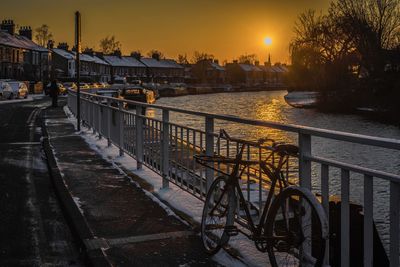 Bridge over river against sky during sunset