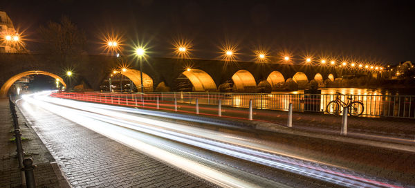 Light trails on bridge in city at night