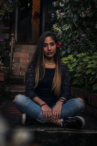 Portrait of young woman sitting outdoors