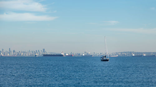 Sailboats sailing on sea against sky