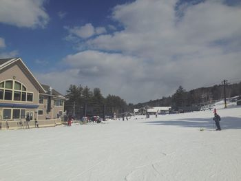 People on snow covered landscape against sky