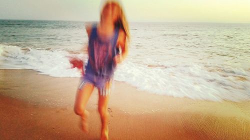 Rear view of woman standing on beach