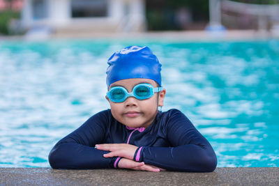 Happy children smiling cute little girl in sunglasses in swimming pool.