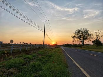 Electricity pylon on field against sky during sunset