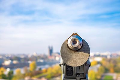 Coin-operated binoculars by landscape against sky