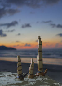Built structure on beach against sky during sunset