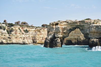 Rock formations by sea against sky