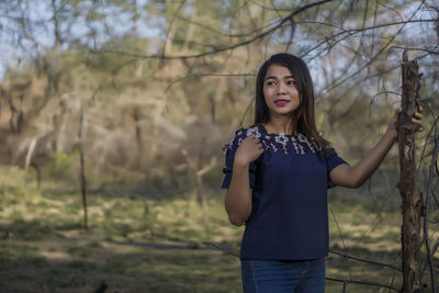 Smiling young woman standing on field