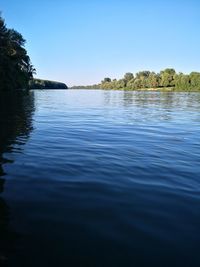 Scenic view of lake against clear blue sky